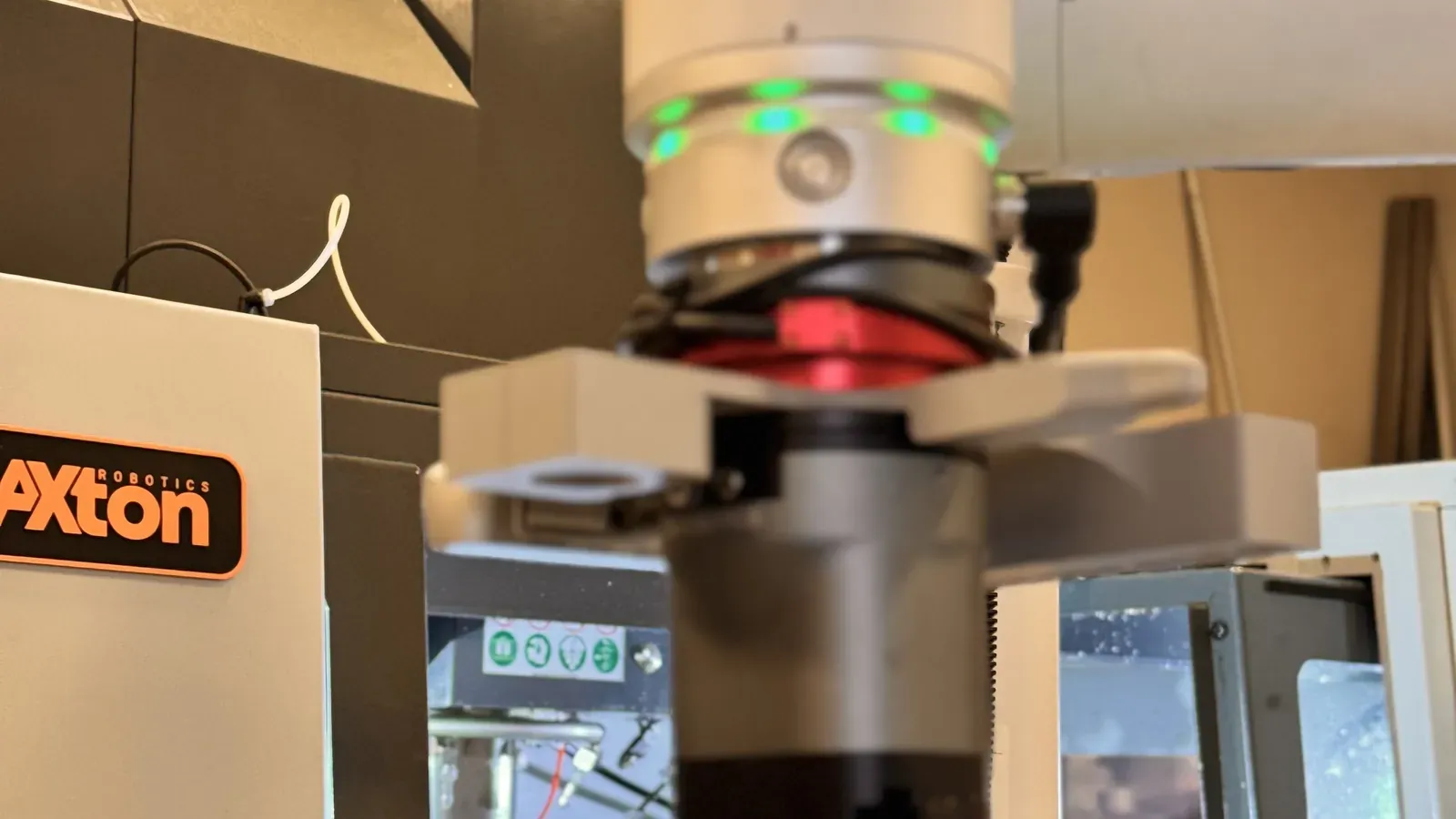 Close-up of a cobot wrist and robotic gripper next to the Axton Robotics station